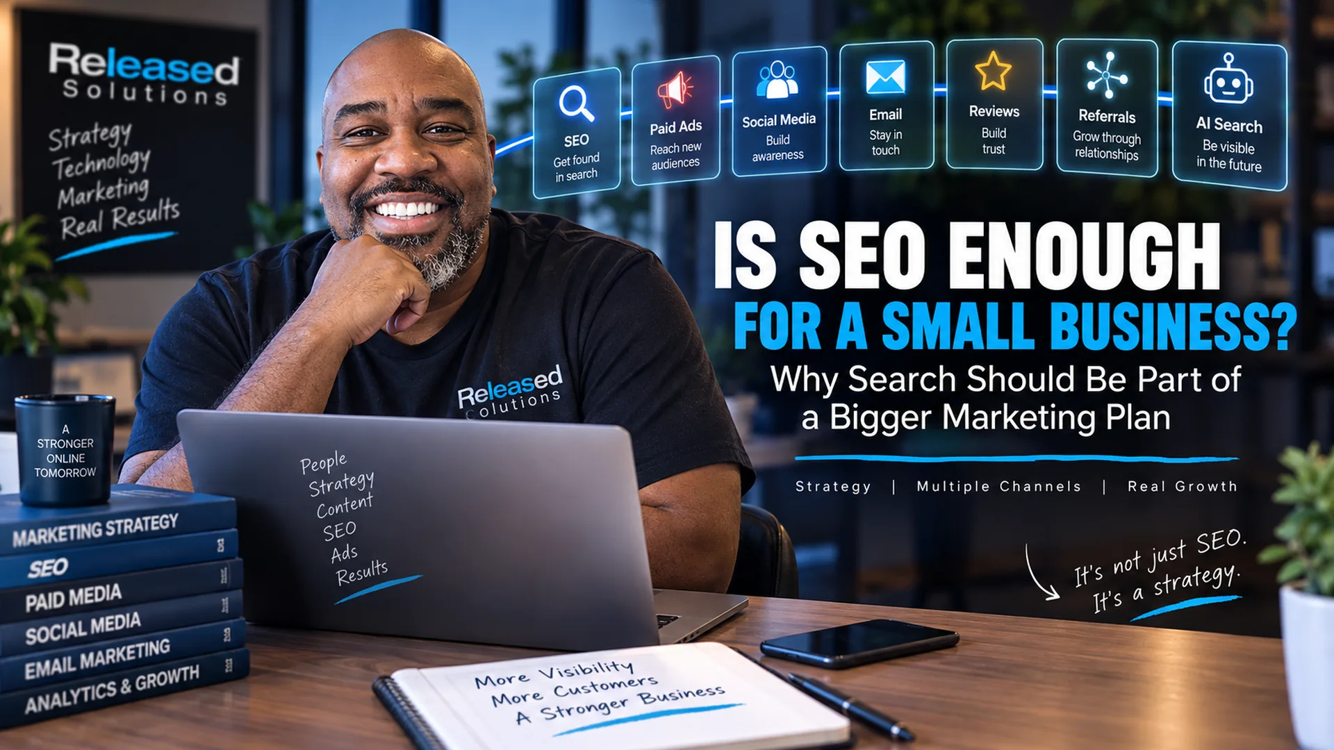 Released Solutions team member at a desk with a multi-channel marketing framework showing SEO, paid ads, social media, email, reviews, referrals, and AI search
